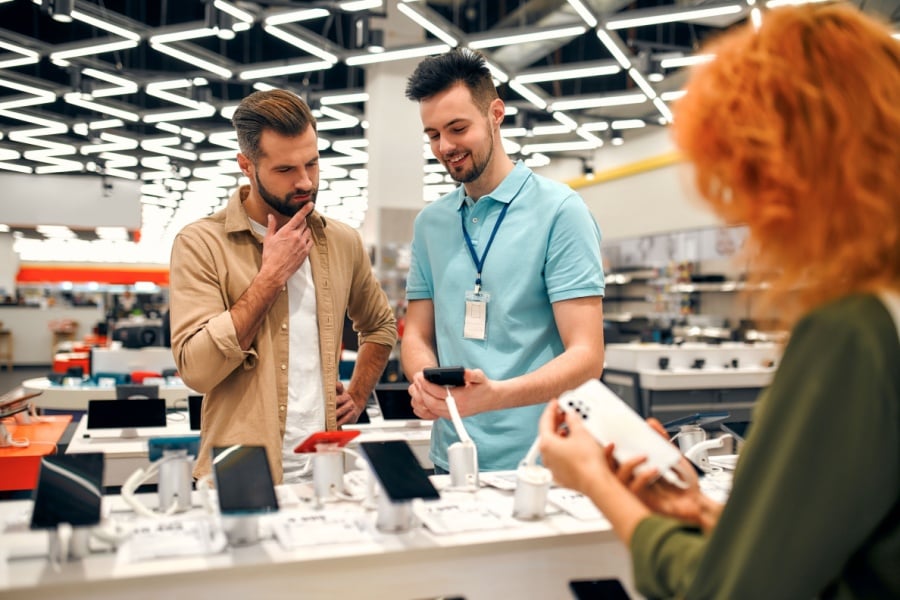 Electronics sales rep shows a customer a new technology