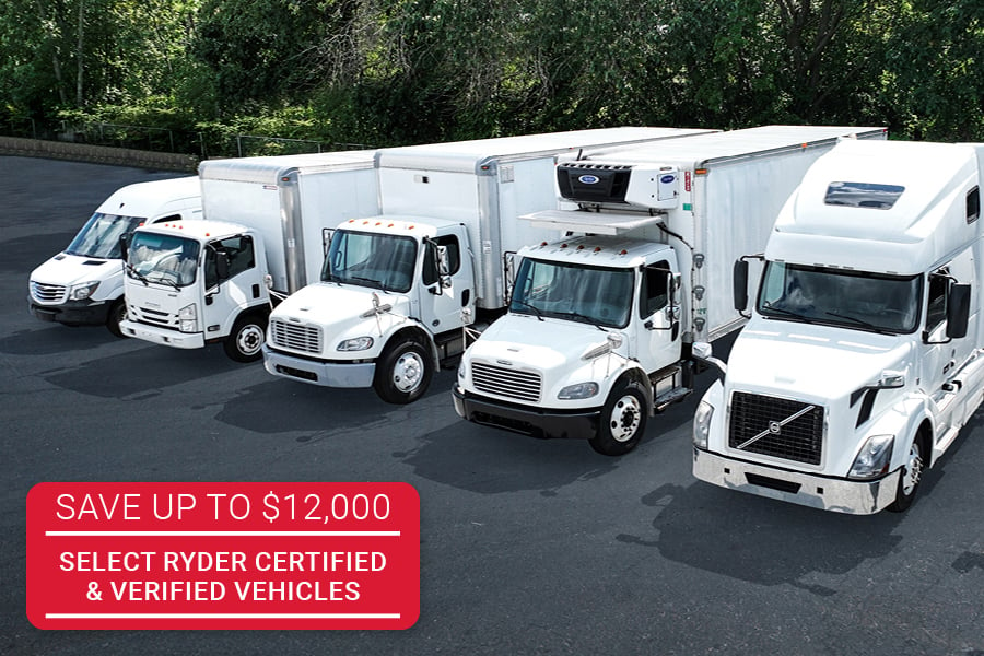 white commercial trucks lined up at a parking lot